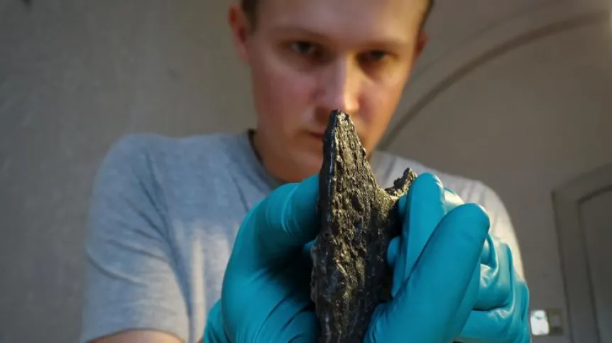 Dr. Leszek Gardeła examining the axe found in a woman's grave in western Norway. Photo by Mira Fricke.