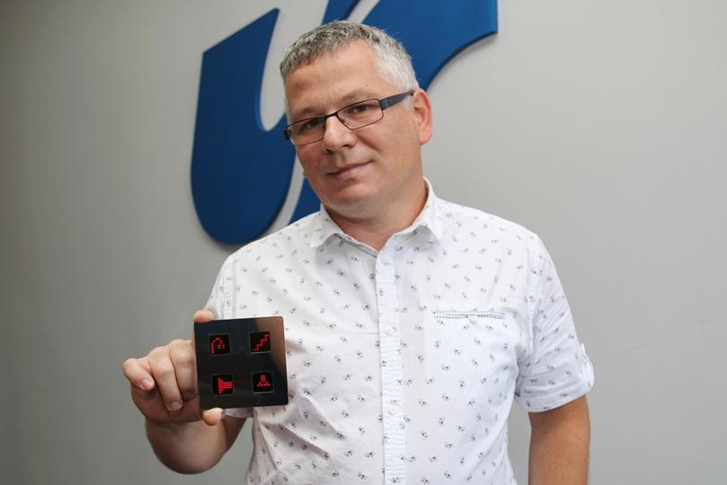 Dr Grzegorz Sapota z Zakładu Komputerowych Systemów Biomedycznych UŚ prezentuje prototyp włącznika dotykowego; Fot. Sekcja Prasowa UŚ