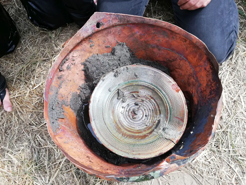 Miedziany kocioł wewnątrz którego znaleziono kilka ceramicznych talerzy. Fot. B. Kontny  Znalezisko ma kilkaset lat