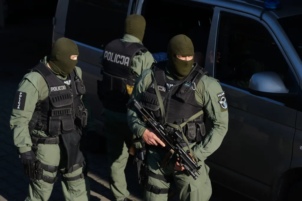 Maski chroniące tożsamość stosowane są nie tylko przez protestujących, ale i przez służby porządkowe. Fot: Poznań, 04.11.2014. Policjanci eskortują zatrzymanego do radiowozu przed budynkiem Prokuratury Apelacyjnej w Poznaniu. (jk/awol) PAP/Jakub Kaczmarczyk