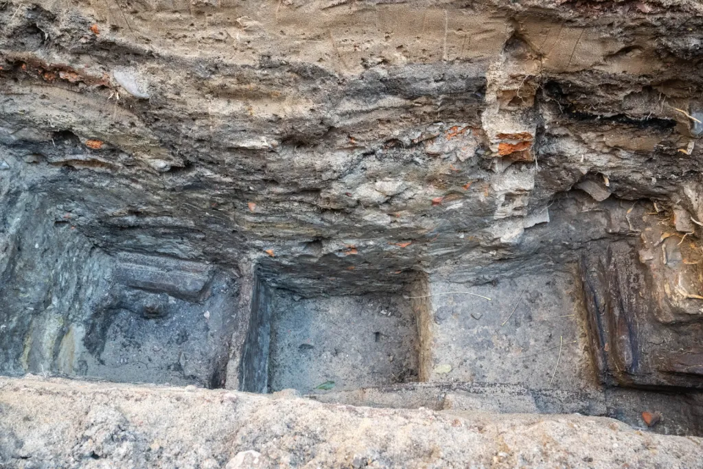 Toruń, 19.11.2025. Fragment nieznanych wcześniej drewnianych konstrukcji z XIII wieku, 19 bm. w Toruniu. Konstrukcje odkryte zostały podczas badań archelogocznych na dziedzińcu Domu Mikołaja Kopernika w Toruniu. To jedne z najstarszych takich znalezisk w mieście. Konstrukcje trafią do konserwacji i staną się elementem przyszłej wystawy stałej muzeum. (mr) PAP/Tytus Żmijewski