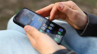 Smartfon w rękach młodej osoby. PAP/Szymon Pulcyn