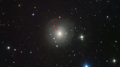 Zdjęcie galaktyki NGC 4993 pokazujące optycznego odpowiednika dla zlewających się gwiazd neutronowych GW170817 (wskazany strzałką). Fotografię wykonano przy pomocy instrumentu VIMOS na teleskopie VLT w Obserwatorium Paranal w Chile. Źródło: ESO. 