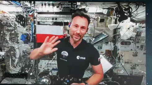 Sławosz Uznański-Wiśniewski (na ekranie) podczas połączenia wideo na żywo ze stacji ISS (jm) PAP/Marian Zubrzycki