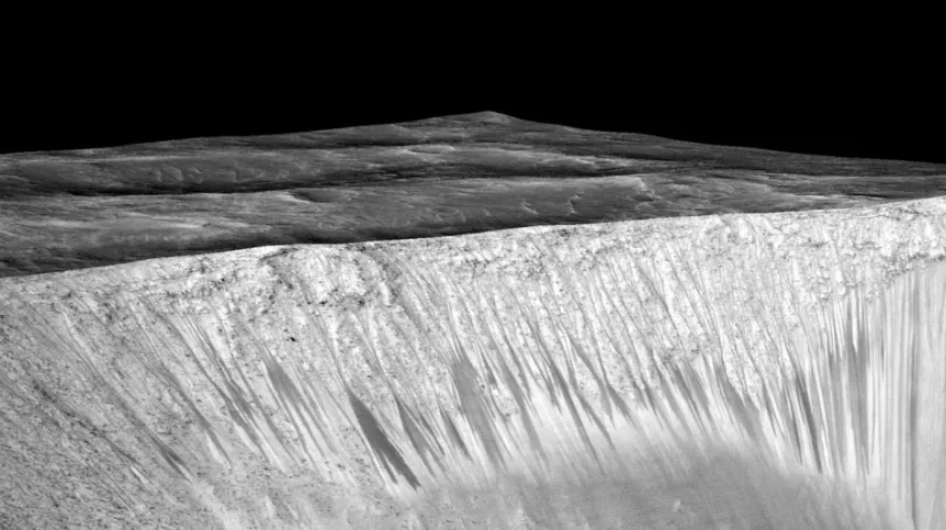 Ciemne pasma na zboczach krateru Garni na Marsie. Źródło: NASA/JPL/University of Arizona.