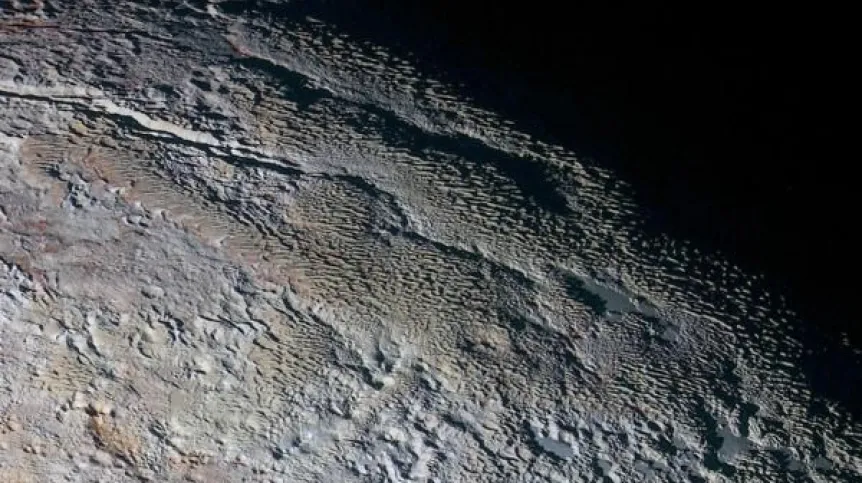 Zdjęcie Plutona w sztucznie uwypuklonych kolorach wykonane przez sondę New Horizons 14.07.2015 r. i przesłane na Ziemię 19 września. Ukształtowanie terenu przypomina nieco widok skóry węża. Źródło: NASA/JHUAPL/SWRI.