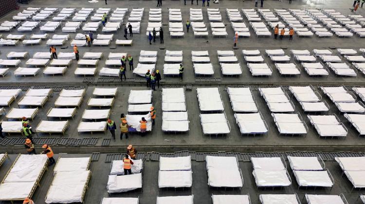 epa08191324 Workers arrange beds in a 2,000-bed mobile hospital, set up in an exhibition center, in Wuhan Hubei province, China, 04 February 2020. EPA/YUAN ZHENG CHINA OUT Dostawca: PAP/EPA.