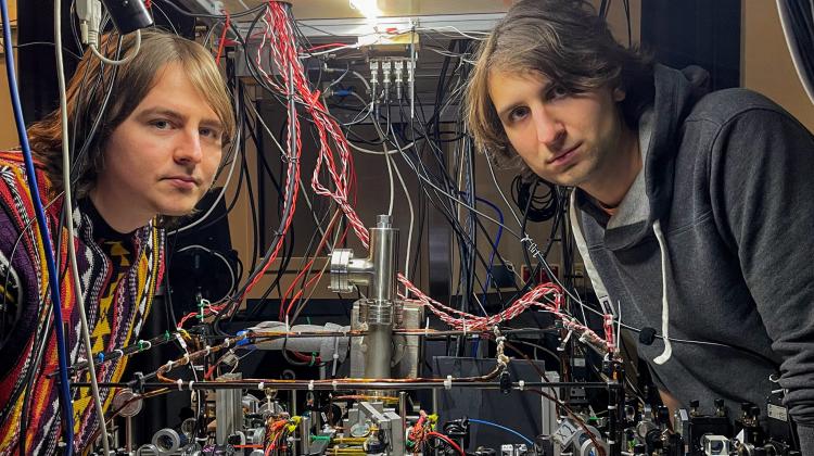 First author Mateusz Mazelan (left) and head of the Quantum Optical Devices lab Dr. Michał Pariak (right) with quantum processor and memory system for light. Credit: University of Warsaw