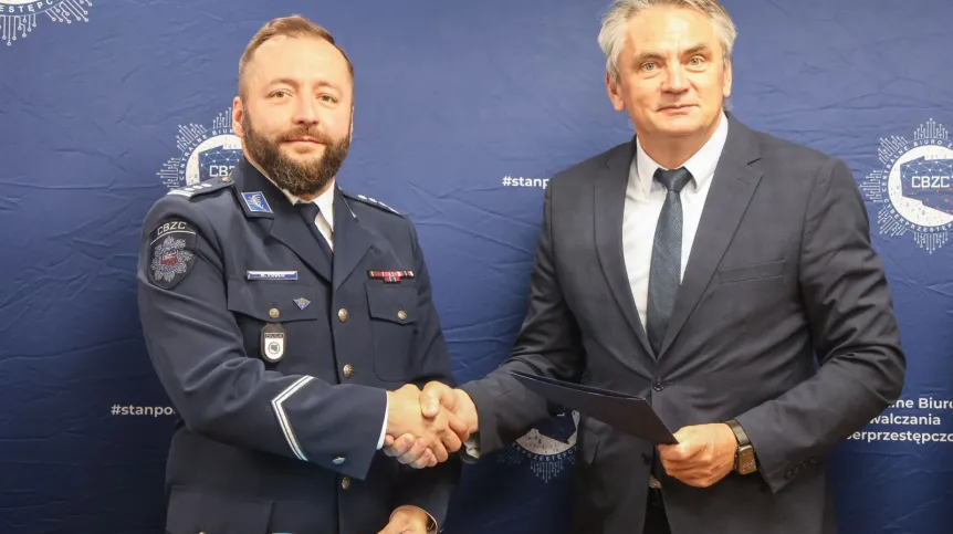 Opole, 06.05.2025. Zastępca Komendanta Centralnego Biura Zwalczania Cyberprzestępczości insp. Michał Pudło (L) oraz rektor Politechniki Opolskiej dr hab. inż. Marcin Lorenc (P) podczas podpisania porozumienia o współpracy między zarządem Centralnego Biura Zwalczania Cyberprzestępczości oraz Politechniką Opolską, 6 bm. w siedzibie Politechniki Opolskiej. PAP/Krzysztof Świderski