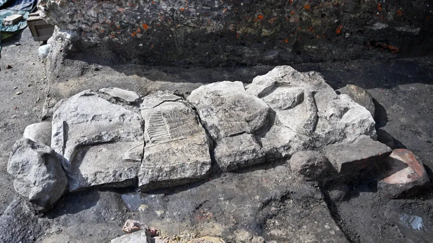 Gdańsk, 08.07.2025. Operacja podniesienia płyty nagrobnej z wizerunkiem rycerza z pocz. XIII w., 8 bm. odkrytej podczas prac archeologicznych na gdańskiej starówce. PAP/Marcin Gadomski