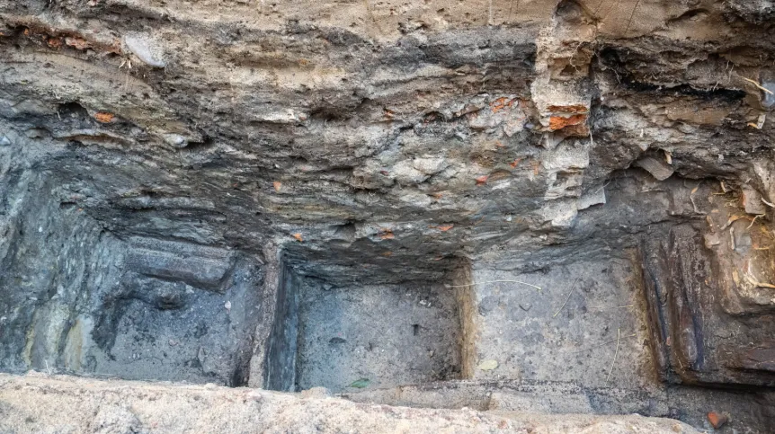 Toruń, 19.11.2025. Fragment nieznanych wcześniej drewnianych konstrukcji z XIII wieku, 19 bm. w Toruniu. Konstrukcje odkryte zostały podczas badań archelogocznych na dziedzińcu Domu Mikołaja Kopernika w Toruniu. To jedne z najstarszych takich znalezisk w mieście. Konstrukcje trafią do konserwacji i staną się elementem przyszłej wystawy stałej muzeum. (mr) PAP/Tytus Żmijewski