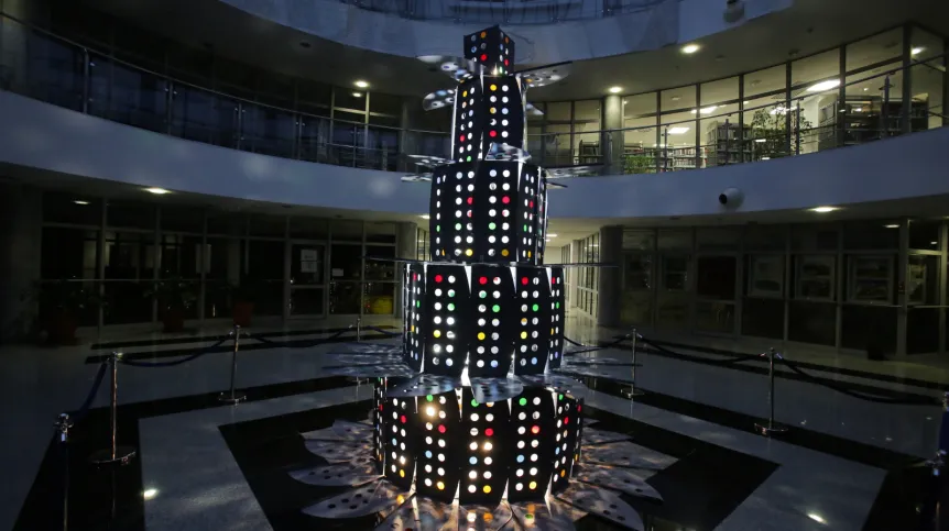 Olsztyn, 09.12.2025. Nietypowa świąteczna choinka w Bibliotece Uniwersytetu Warmińsko-Mazurskiego w Olsztynie, 9 bm. Biblioteka słynie z oryginalnych choinek. W tym roku do budowy drzewka wykorzystano metalowe ograniczniki do stolików, które w przeszłości oddzielały poszczególne stanowiska dla studentów korzystających z czytelni. Użyto też kolorowej folii, która podświetlona imituje bombki choinkowe. PAP/Tomasz Waszczuk