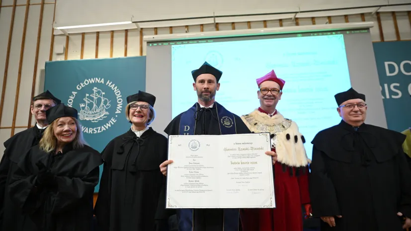 Warszawa, 10.04.2026. Astronauta Europejskiej Agencji Kosmicznej Sławosz Uznański-Wiśniewski (4L) odbiera tytuł doktora honoris causa SGH podczas uroczystości w auli głównej Szkoły Głównej Handlowej w Warszawie, 10 bm. Obok rektor SGH dr hab. Piotr Wachowiak (2P) i promotor, dr hab. prof. SGH Roman Sobiecki (P). (jm) PAP/Marcin Obara